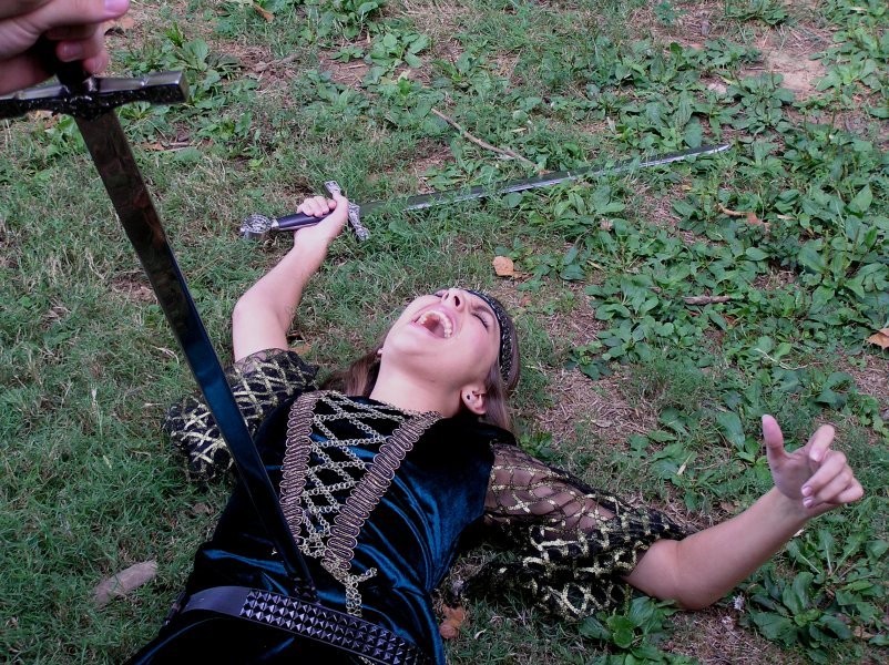cute dead girl is stabbed in the belly in a sword fight